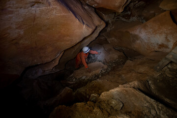 Persona explorando una caverna afótica con equipo, casco e iluminación 
