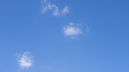 A clear blue sky filled with fluffy white clouds, a tranquil atmosphere of natural beauty and no people in sight.