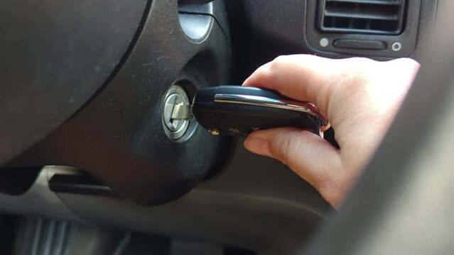 Hand with car keys starts the engine. Car ignition.