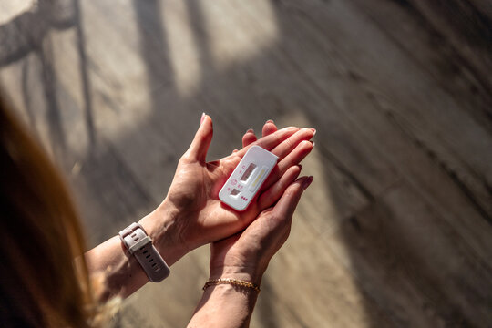 woman holding a pregnancy test, representing reproductive health, excitement, worry, hope, and anticipation. The image is related to pregnancy, motherhood, family planning, home testing, diagnosis, a
