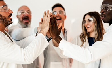  A diverse group of scientists from different ethnic backgrounds are gathered together, cheering...