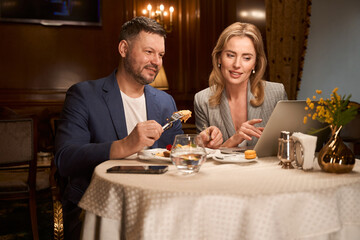 Couple choosing place to rest on holidays during lunch in cafe