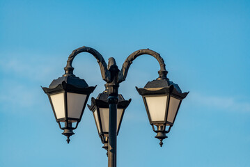 Fototapeta na wymiar A street lamp on a blue sky background.