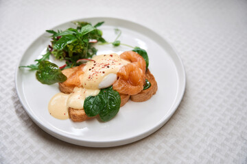 Toast with smoked salmon and eggs benedict on plate