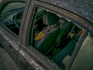 A cropped front view of a burned and abandoned rusty cars