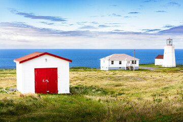 Fototapeta na wymiar Lighthouse and East Coast buildings overlooking the Atlantic Ocean at Cape St. Mary's Newfoundland Canada..