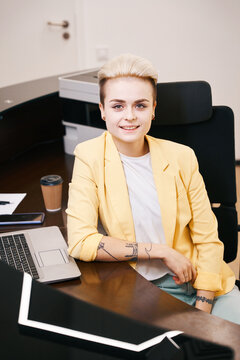 Happy young woman boss sitting at workplace