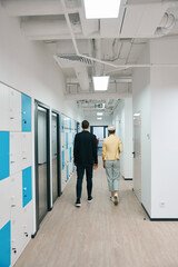 Colleagues walking along storage cells to office