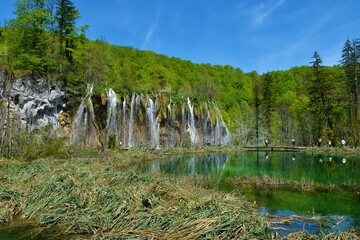 View of Mali Prštavac waterfall and Milino jezero lake bellow with people walking on the walkway...