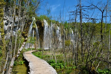 Wooden walkway leading bellow Mali Prštavac waterfall at Plitivice lakes in in Lika-Senj county,...