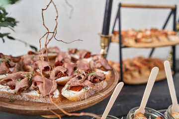 Delicious canapes with pork ham with dried tomatoes. Tasty buffet table. Summer party. Catering concept