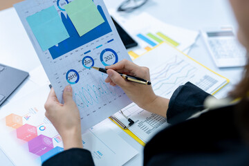 Young successful employee business woman in black shirt hold paper account document work stand at workplace white desk with laptop pc computer at light modern office indoors achievement career concept