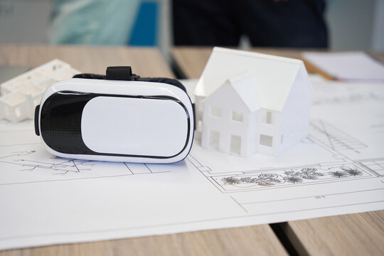 Virtual reality headset lying on house blueprint