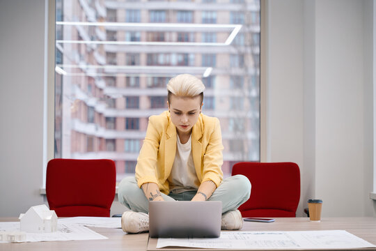Woman working on laptop sitting on the work desk