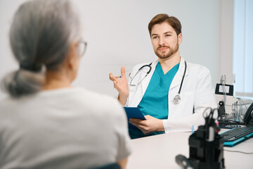 Young therapist consults an elderly lady in a medical center