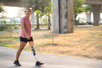 Exercise woman with prosthetic leg in the park - obrazy, fototapety, plakaty