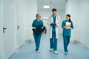 Three doctors are walking along the corridor of diagnostic department