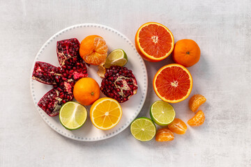 Fresh fruits background with citrus fruits and juicy pomegranate