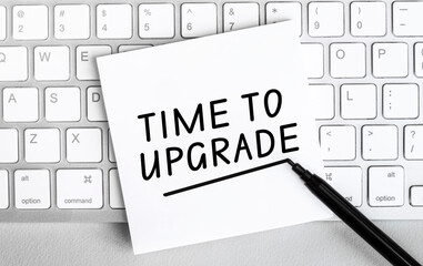 White paper with text Time to upgrade lying on the keyboard