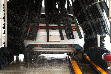 Car wash, car wash concept with automatic car wash machine and car washes by workers.
