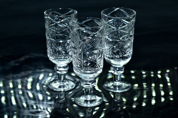 Crystal glasses stand on a dark surface.