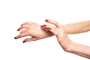A girl smearing a handful of hand cream on her hand with red manicure. Photo isolated on white background.