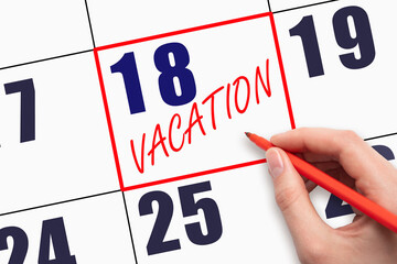 18th day of the month. Hand writing text VACATION on calendar date.