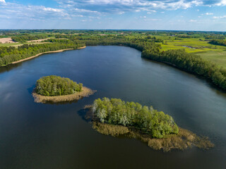 Naklejka na ściany i meble Beautiful drone nature landscape of fields, meadows, forest and lake - sunny day in Poland, Mazury aerial view