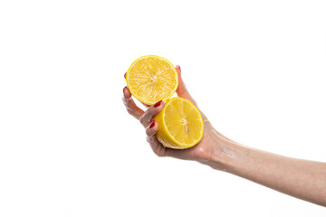 The girl's hand holds a cut round slice of fresh tropical orange. An orange in a woman's hand on a white background is isolated. Orange slice. The girl gently holds a citrus in hand