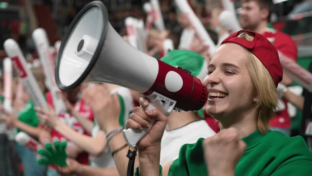 Loud woman scream megaphone sport stadium. Crazy mad fan shout bullhorn close up. Insane female cheer team. Furious person yell loudspeaker. Active girl win goal. Wild crowd watch game cup match arena