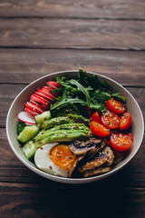 Healthy food. Bowl with eggs, mushrooms, avocado, arugula, cucumber, cabbage, tomato and radish