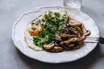 Breakfast scrambled eggs with mushrooms and arugula microgreens