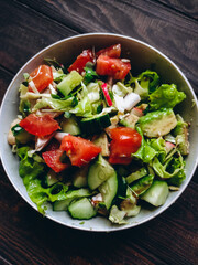 Summer green healthy salad with avocado, arugula microgreens, cucumber, cabbage and tomatoes