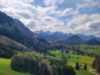 Fototapeta na wymiar Neuschwanstein Castle and Expansive Fields in the Bavarian Alps of Southern Germany
