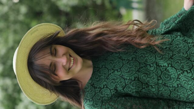 Woman with natural makeup, floral cosmetics for skin of the face, girl posing in flower branches of blooming apple tree in spring. Vertical Video