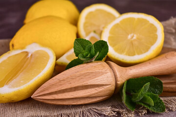 Wooden manual citrus juicer and fresh lemons.
