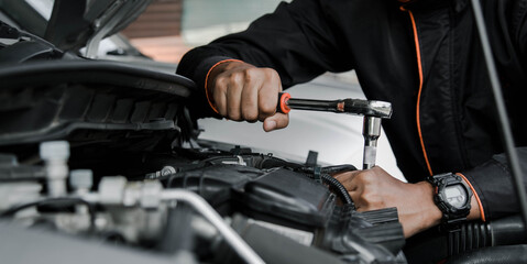 Mechanic fixing a car at home. Repair and service.