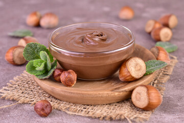 Delicious chocolate spread with hazelnut flavor on a gray background.	