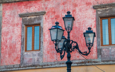 Farola de estilo clásico en Castro, Italia. Farola de cuatro brazos ubicada frente a la fachada...