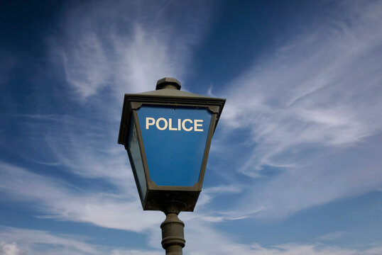 Police lamp outside a police station against a blue sky