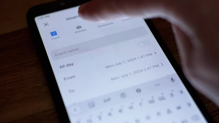 Girl is Adding a New Event in Electronic Calendar App on Smartphone Screen. Hand flips through the page in search of a date. Adding mom's birthday to the calendar app on a mobile phone. Close up.