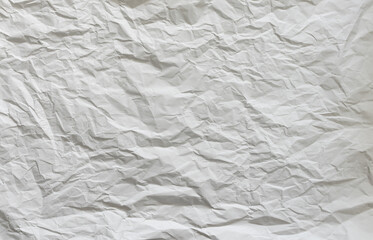 Wrinkled white paper background. Empty crumpled material with a random structure. Abstract and wavy pattern as creative backdrop.