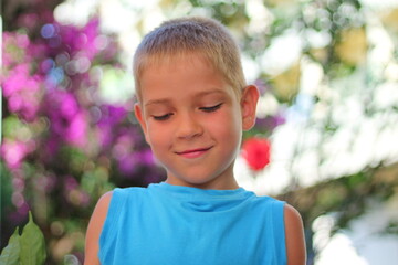 A confused schoolboy looks down. Cute embarrassed guy. Human emotions and body language