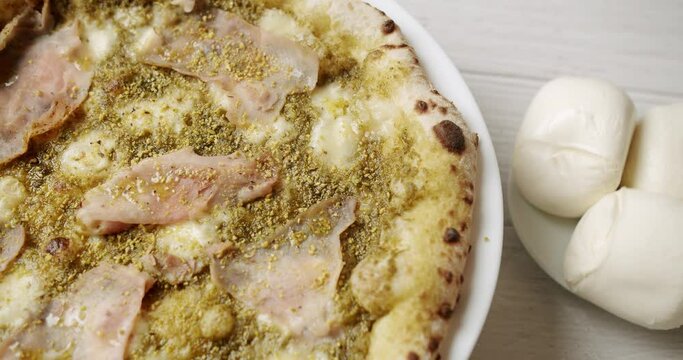 Pizza with Meat, Pesto, Cheese and Parmesan fresh out of the oven ready to eat. Delicious Italian pizza. Napoli Pizza. Food Service on white table and ingredient. Tasty Pizza with Cheese and Parmesan.