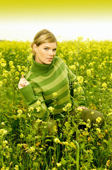 Fototapeta premium Young business woman relaxing on green meadow full of yellow flowers