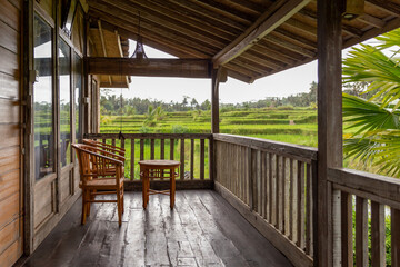 A small terrace in a wooden house, surrounded by rice fields, Ubud, Bali