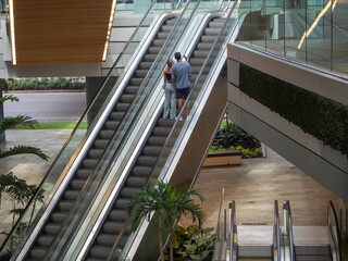 A couple going up an escalator.