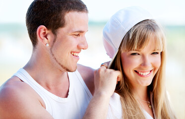 Happy couple standing on the beach near the ocean