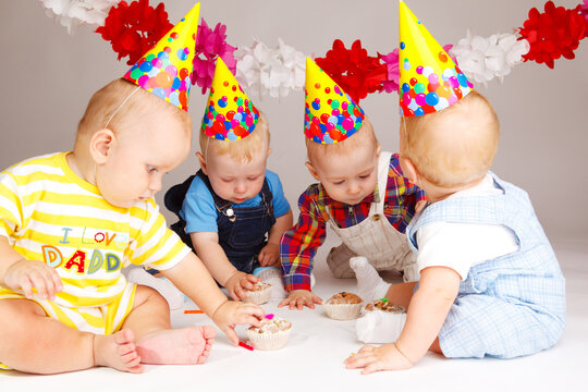 Four babies taking their birthday cakes