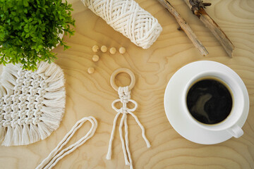 Flat lay Cup of coffee on wooden serving tray with macrame decoration. Minimal bohemian lifestyle concept for blog and social media